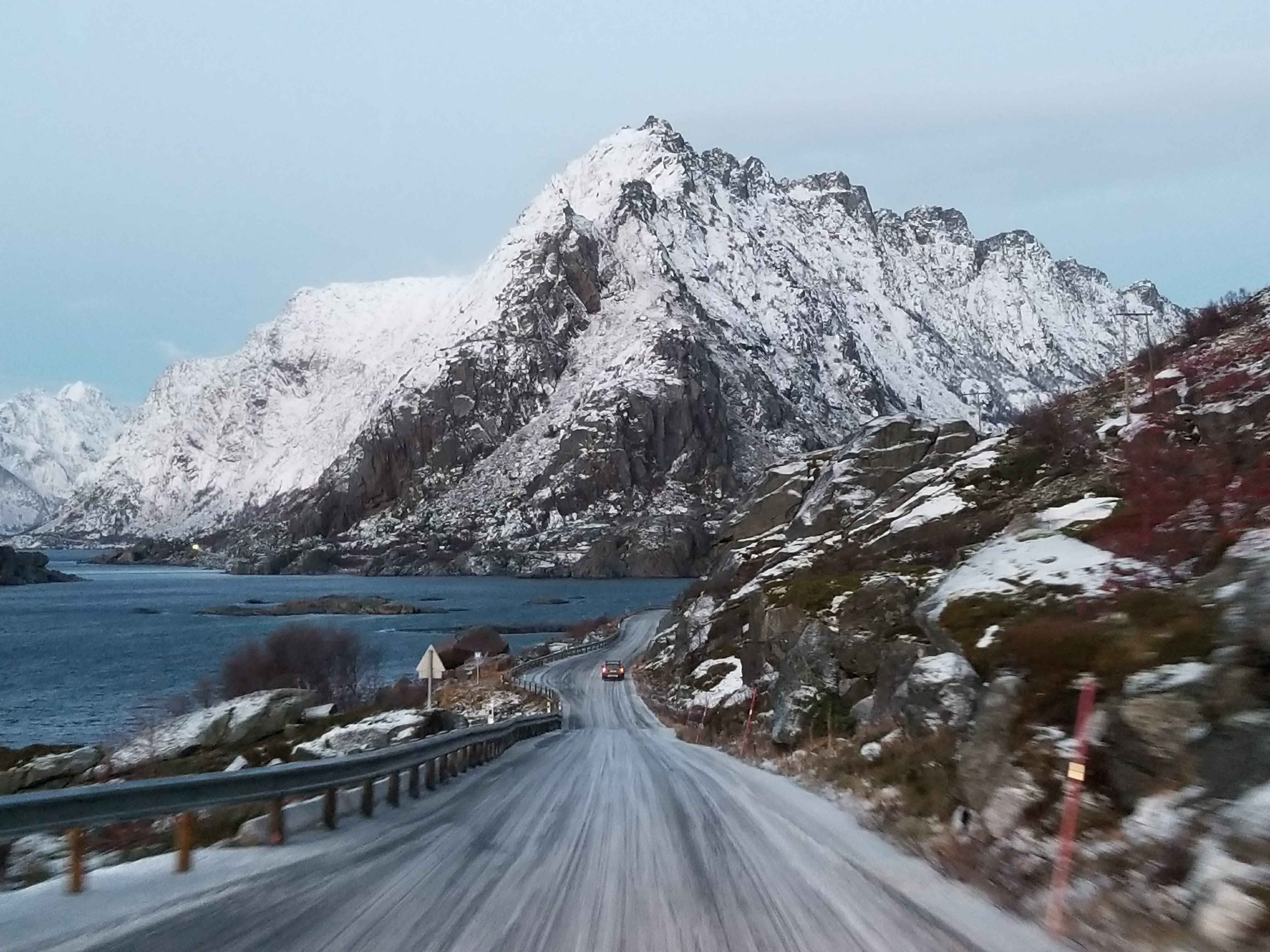 A picturesque road surrounded by snowcapped mountains in the Lofoten Islands of Norway